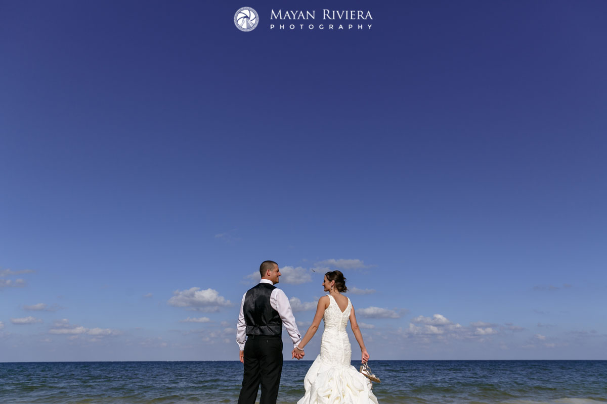 NewlywedsOnBeachHoldingHands