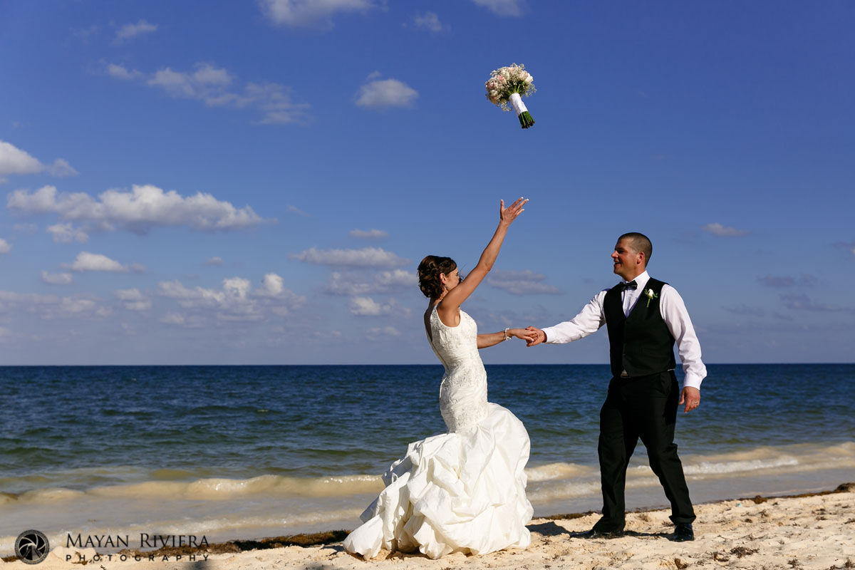 BrideTossesBouquetHoldingGroomsHand