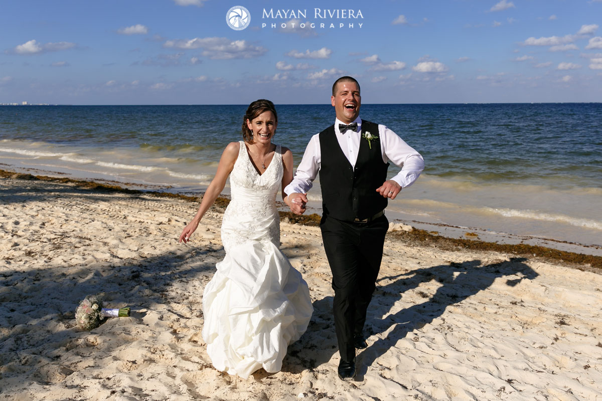 NewlywedsRunOnBeachHoldingHands