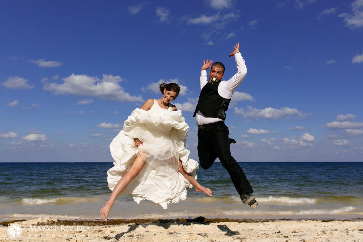 NewlywedsJumpForJoyOnBeach