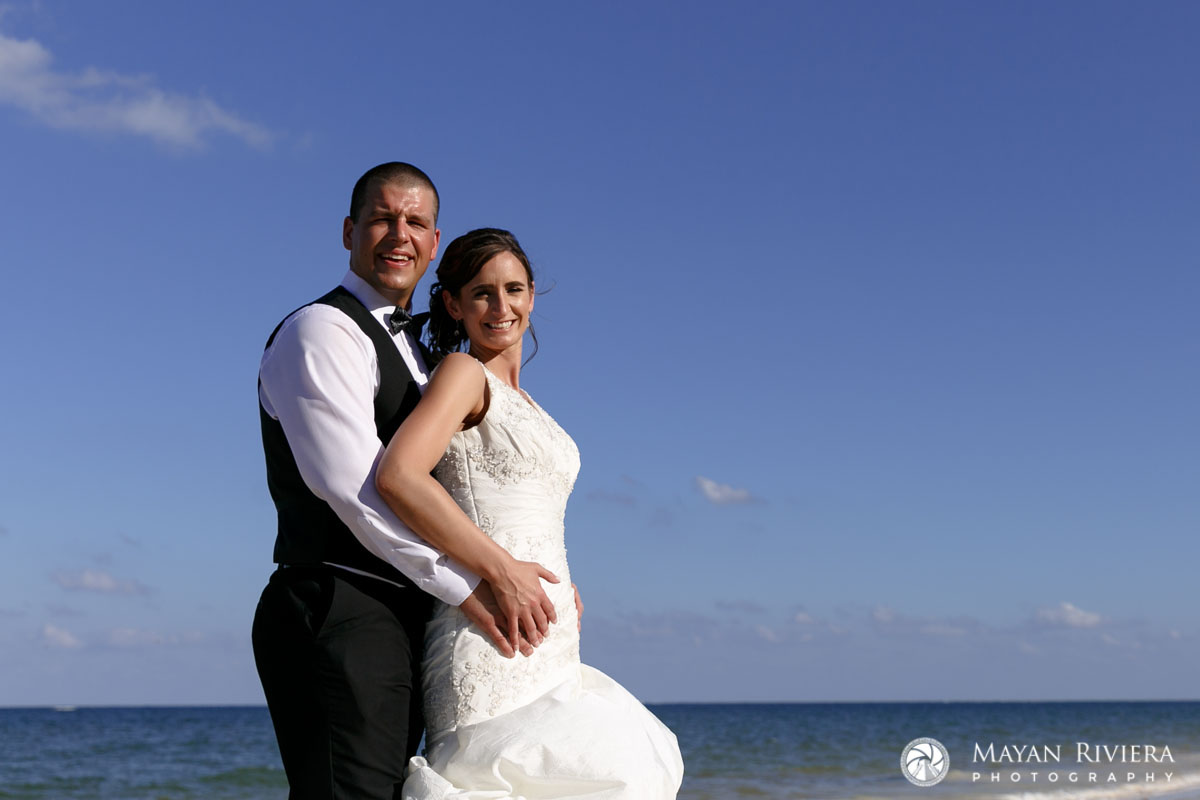 NewlywedsEmbraceOnBeach