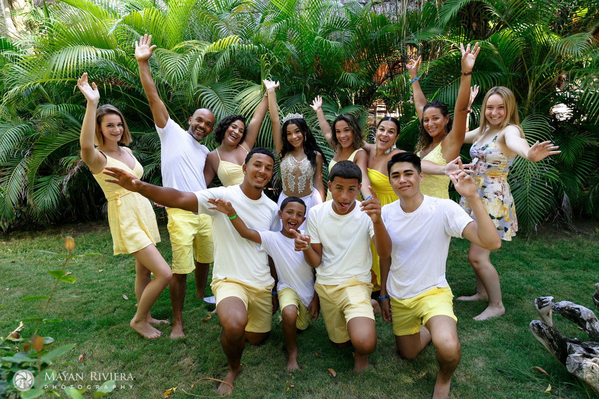 MelaniePosesOnLawnWithFamilyCheering