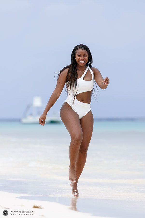 SmilingBrideJumpingForJoyOnBeach