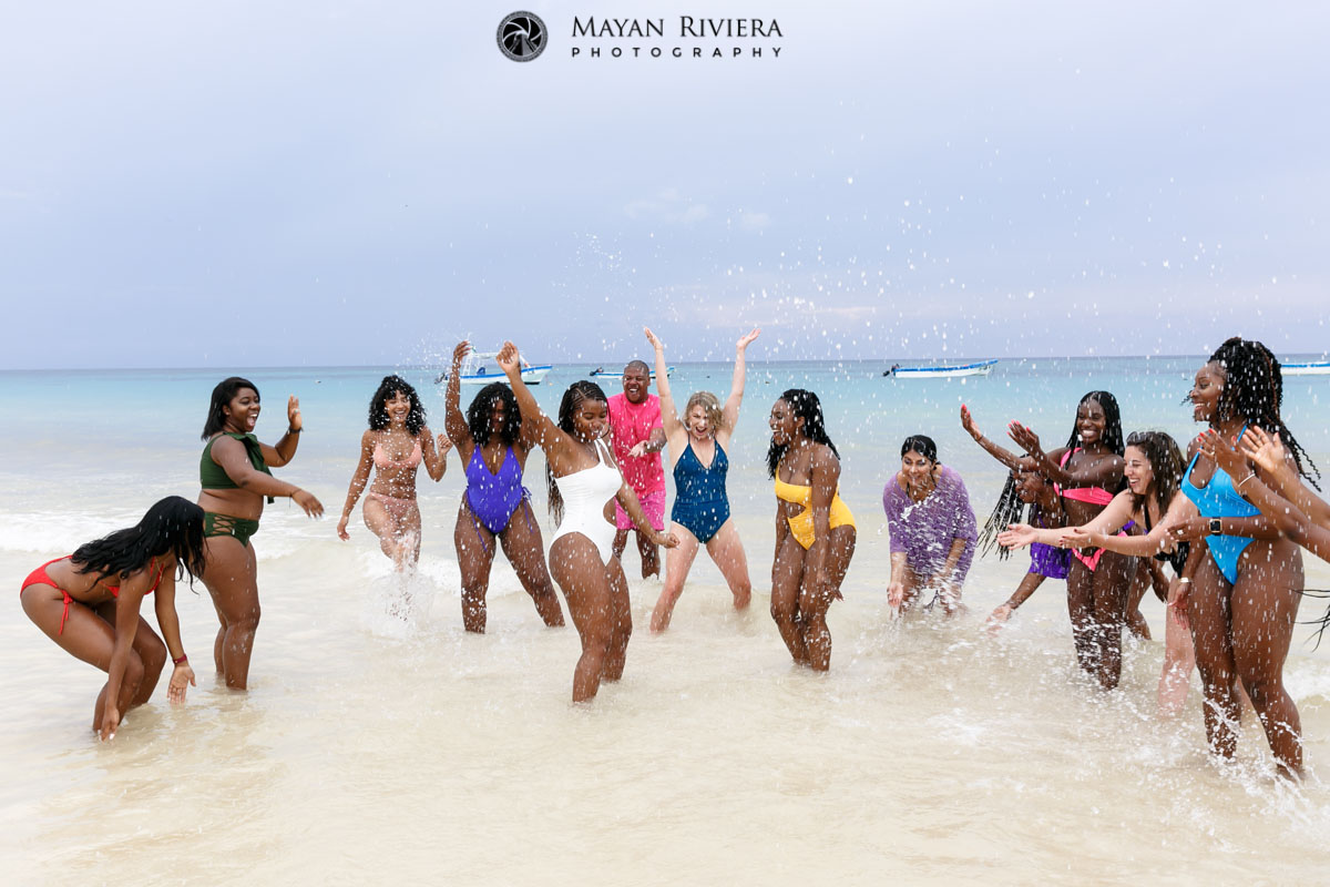 Entourage splashes cheering bride standing in the ocean