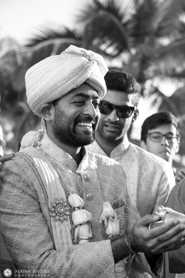 HappyHinduGroomHoldsShellOnBeach