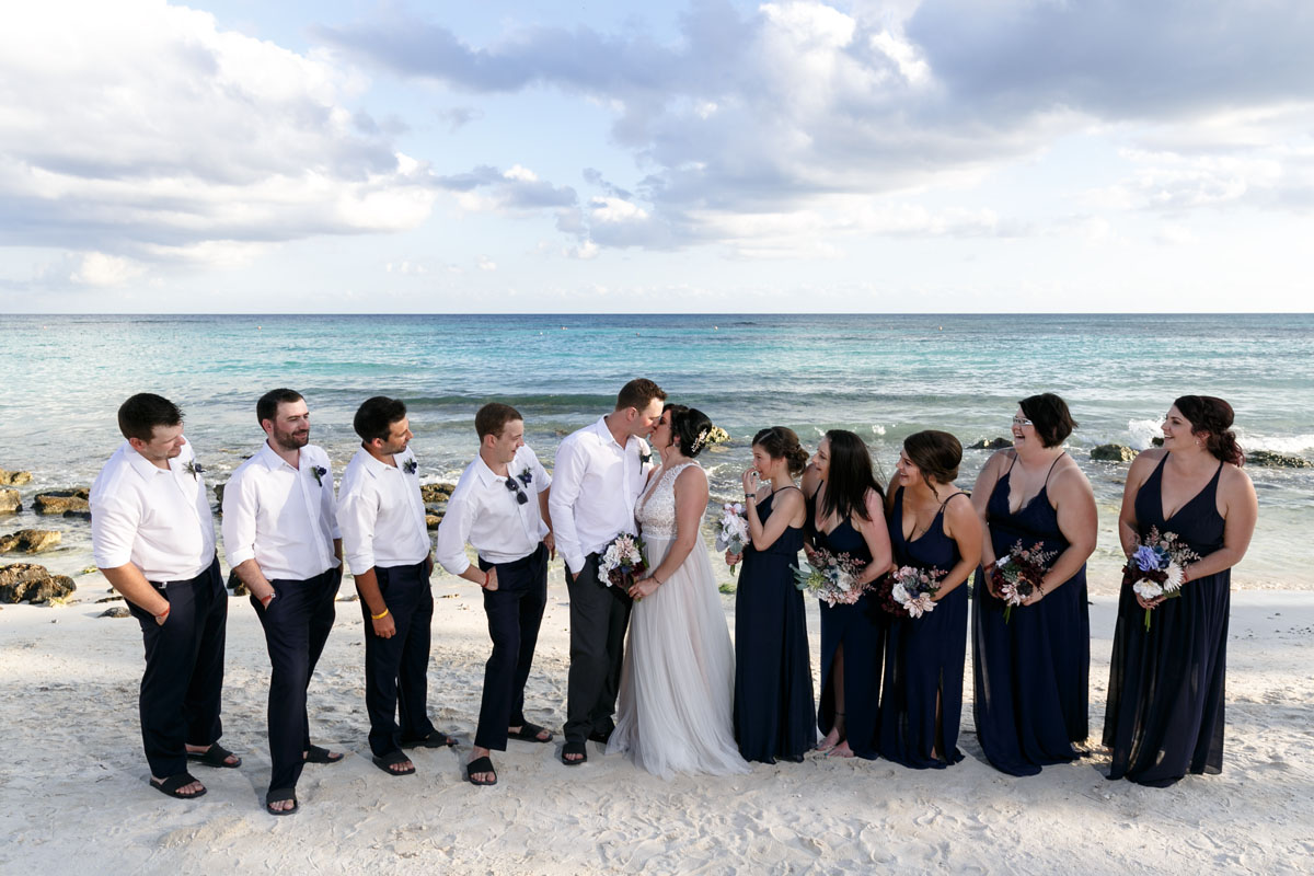 NewlywedsKissWatchedByWeddingParty