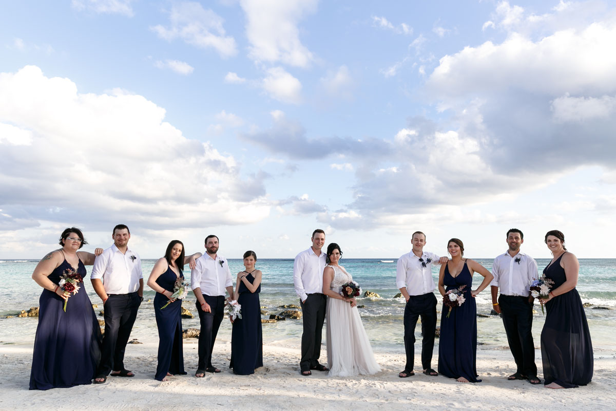 NewlywedsPoseWithWeddingPartyOnBeach