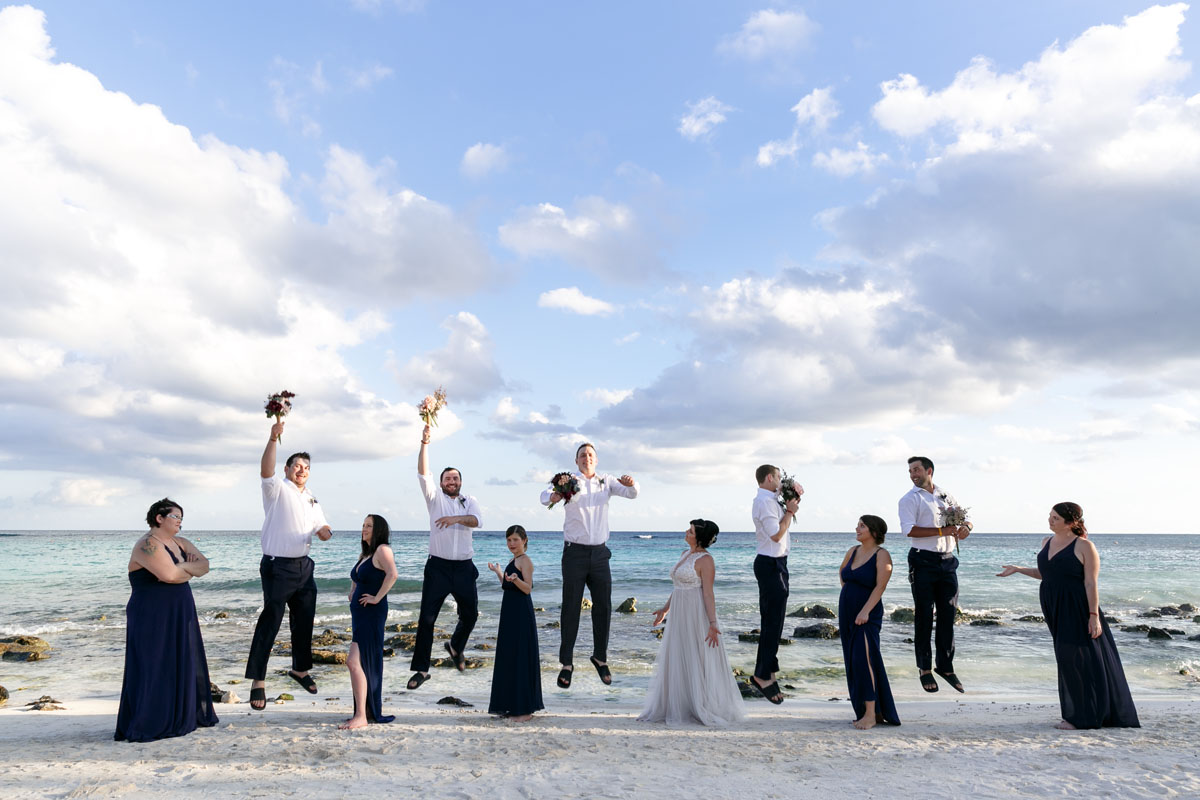 WeddingPartyGuysJumpForJoyOnBeach