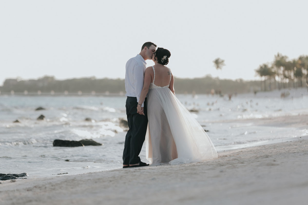 NewlywedsKissOnBeach