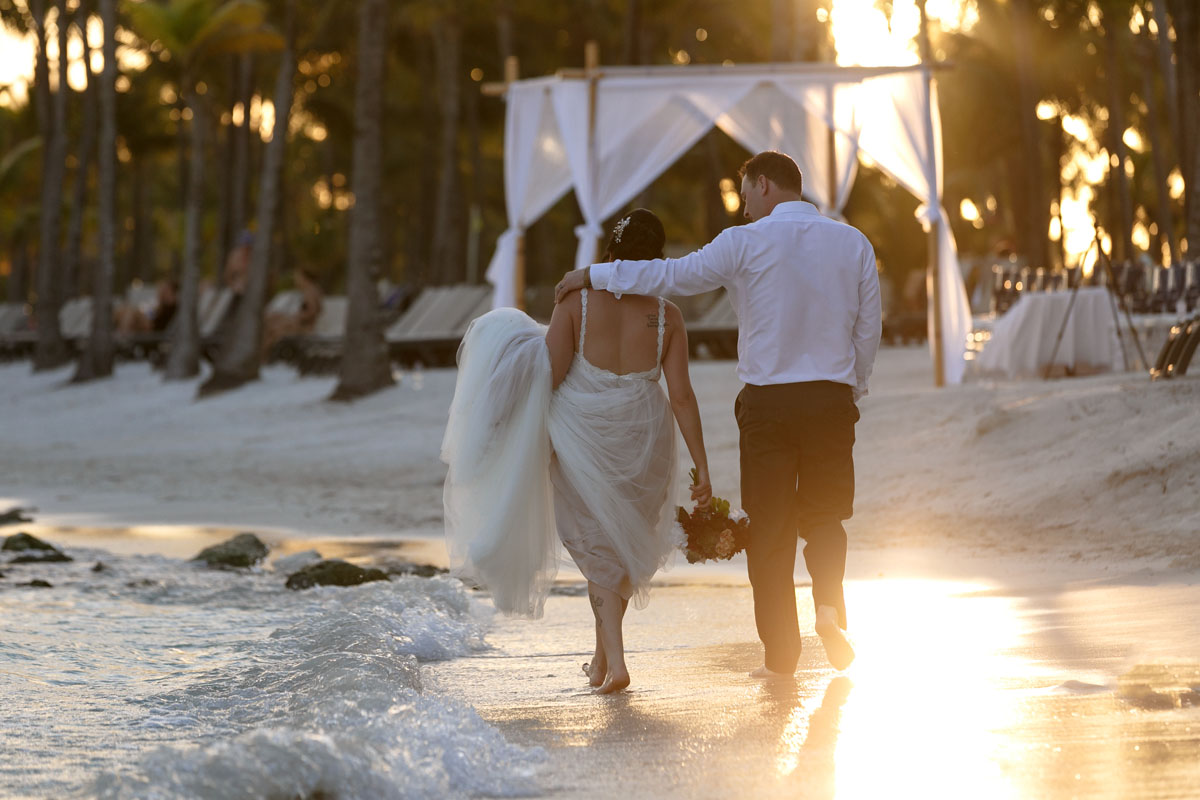 NewlywedsWalkOnBeachAtSunset