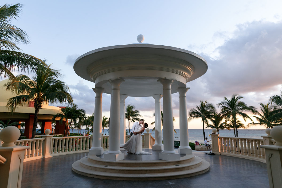 Newlyweds dip in a kiss under the signature Barcelo dome