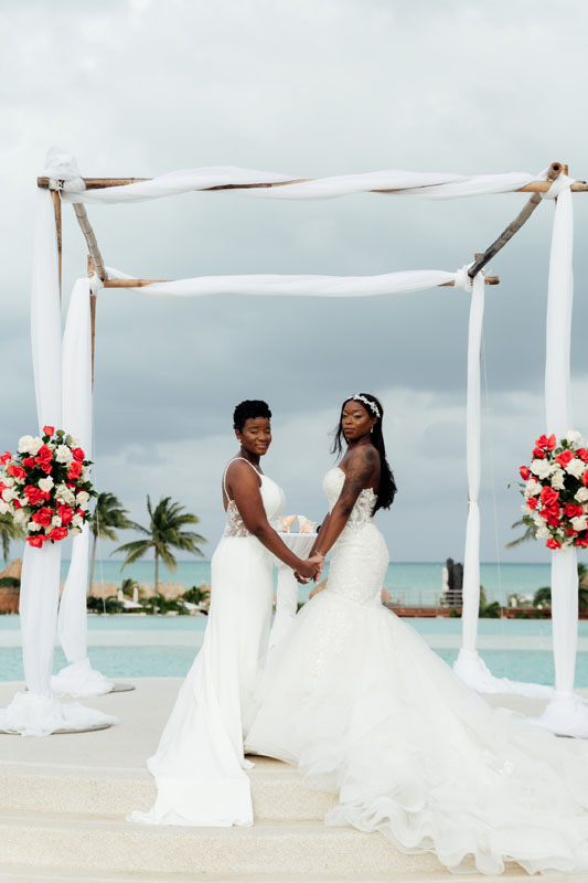 WeddingCoupleHoldHandsAtCeremony