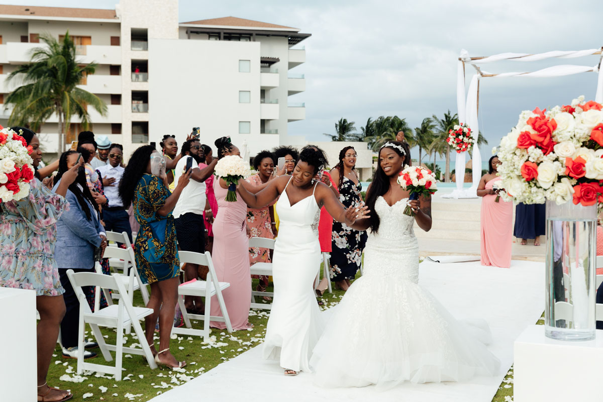 CheeringNewlywedsWalkOutHoldingHands