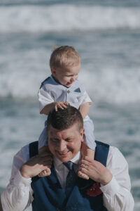 SonSitsOnDadsShouldersAtBeach