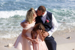 GroomsmansFamilyPosesOnBeachKissing