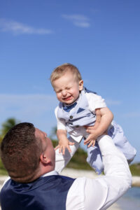 DadsTossesLaughingSonAtBeach