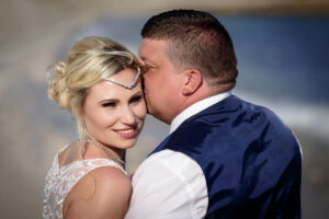 NewlywedsKissOnBeach