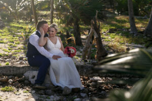 NewlywedsKissSittingOnJungleLog