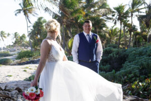 NewlywedsPoseOnBeachRocks