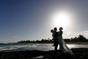 NewlywedsPoseOnBeachRocks