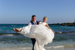 GroomTwirlsBrideOnBeach