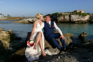 NewlywedsPoseOnBeachRocks