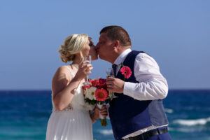 NewlywedsKissHoldingChampagne