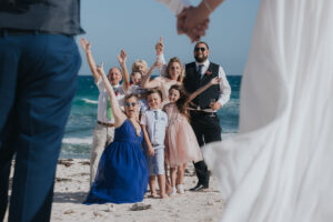 CheeringGuestsFramedByNewlywedsHoldingHands