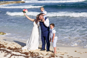 CheeringNewlywedsPoseWithSonsOnBeach