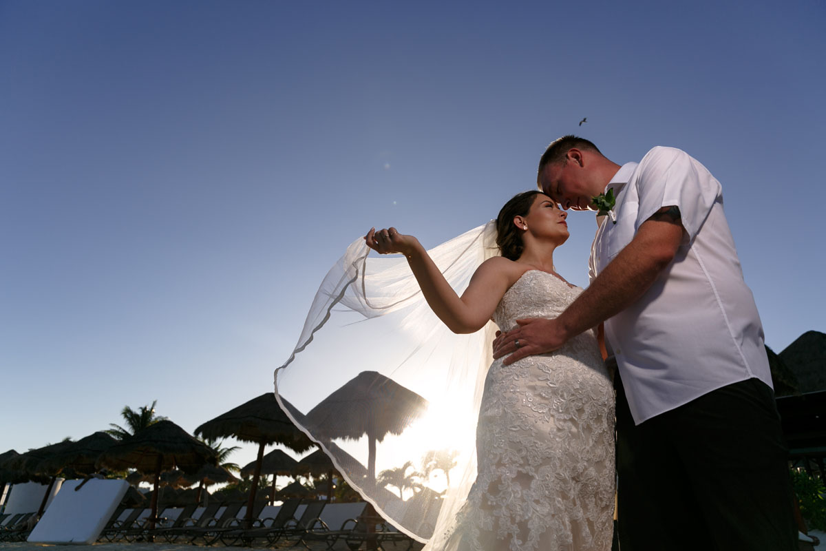 NewlywedsPoseOnBeachWithFloatingVeil