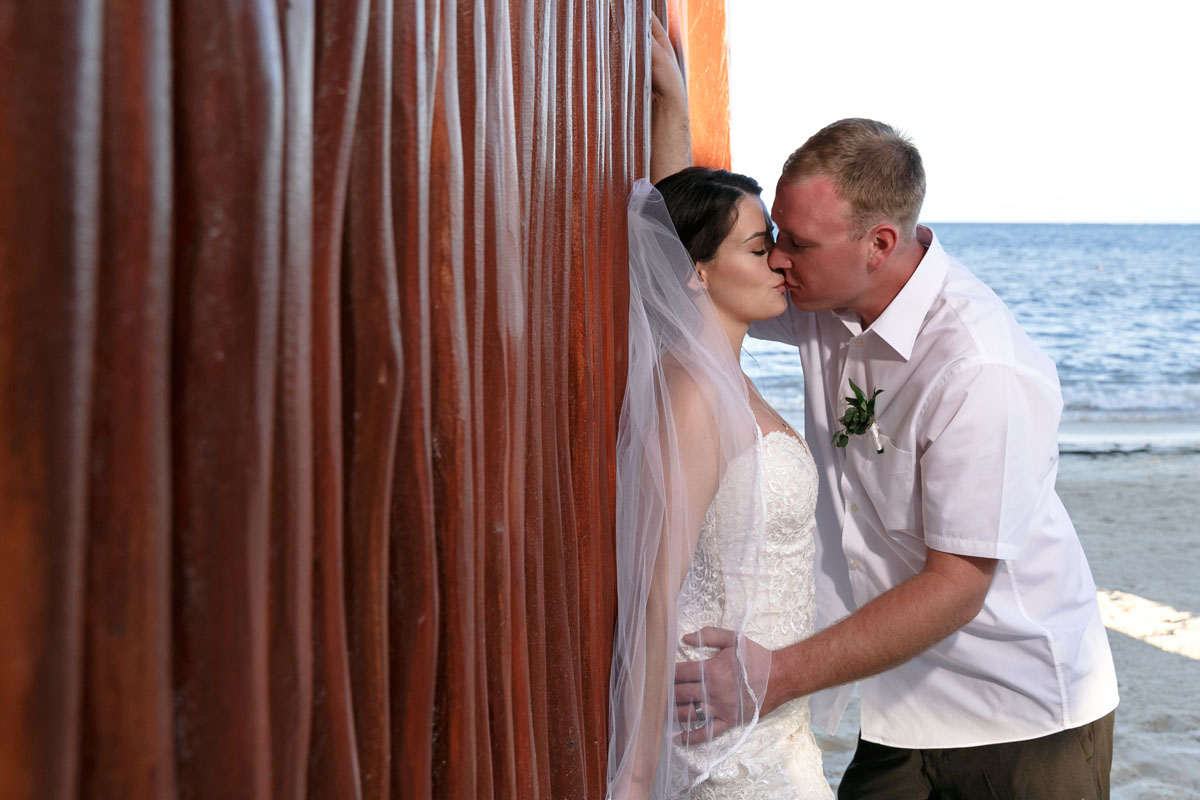 NewlywedsKissByReedWall