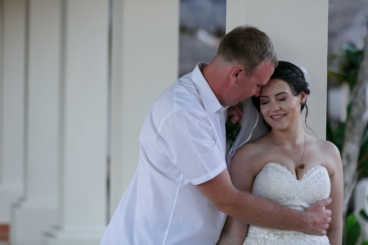 NowSapphireNewlywedsPoseByPillars