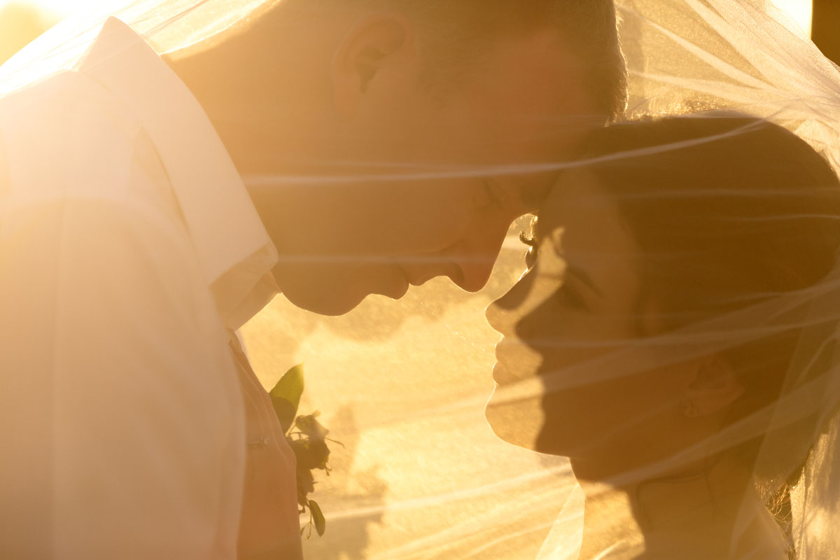 NowSapphireNewlywedsPoseUnderVeilAtSunset