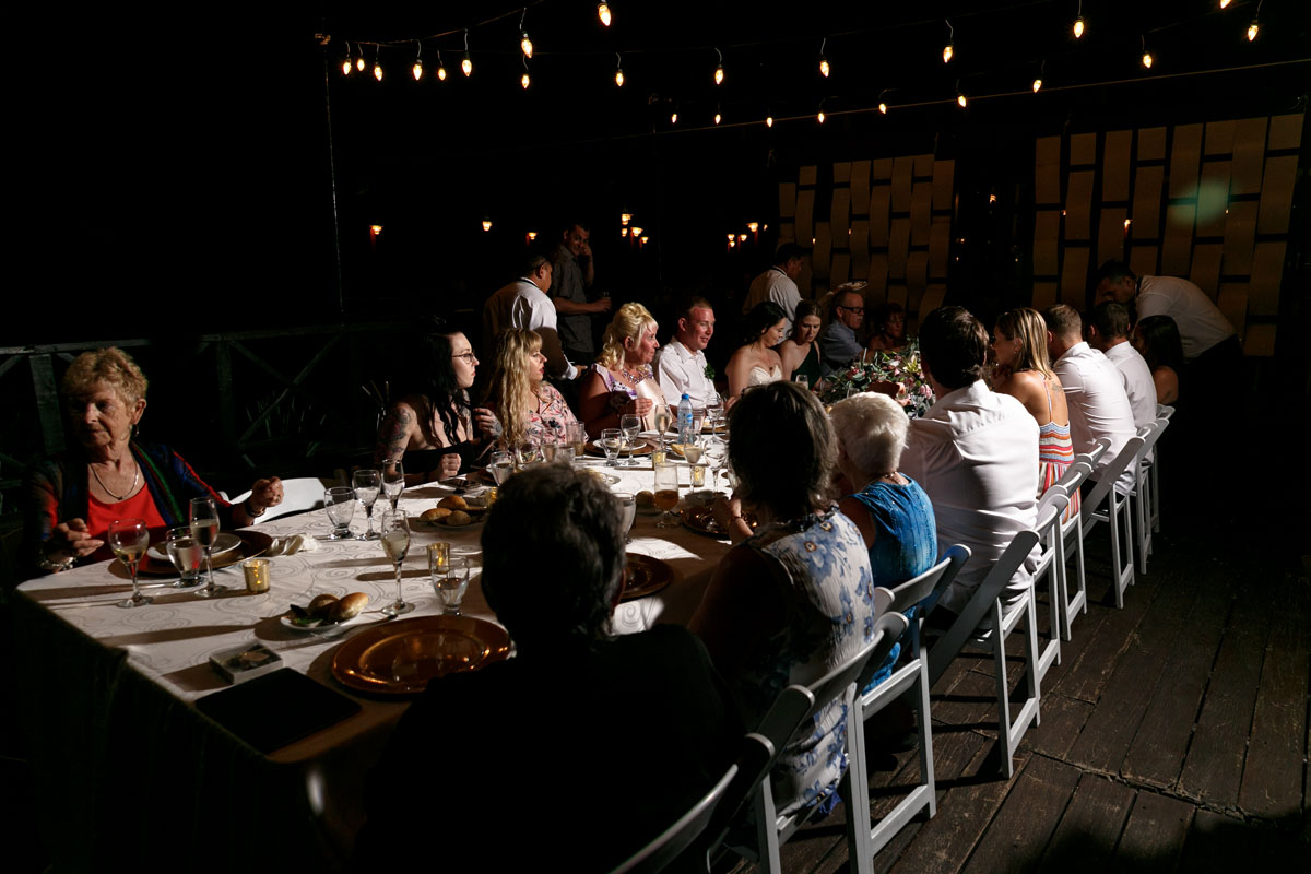 NowSapphireNewlywedsSitWithReceptionGuests