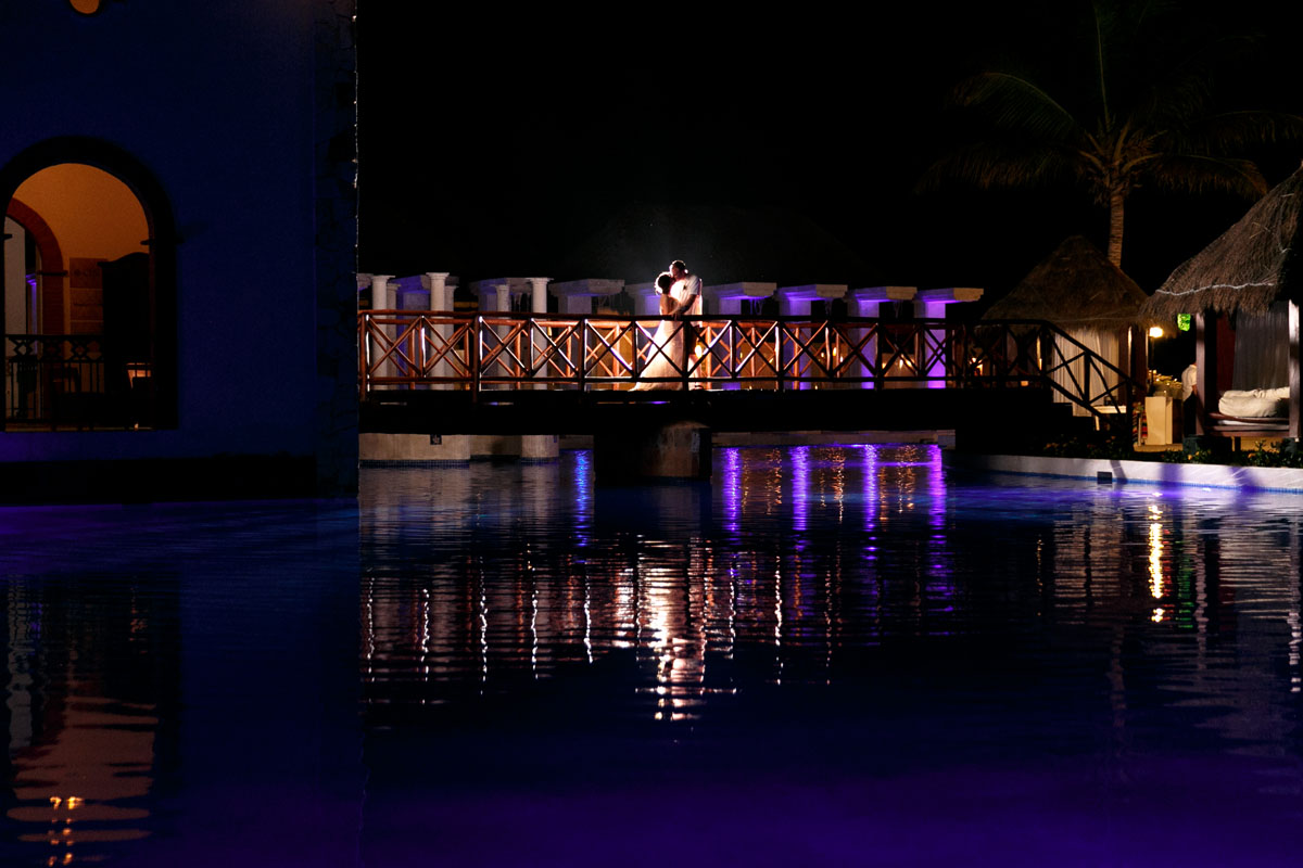 NewlywedsKissOnRomanticBridge