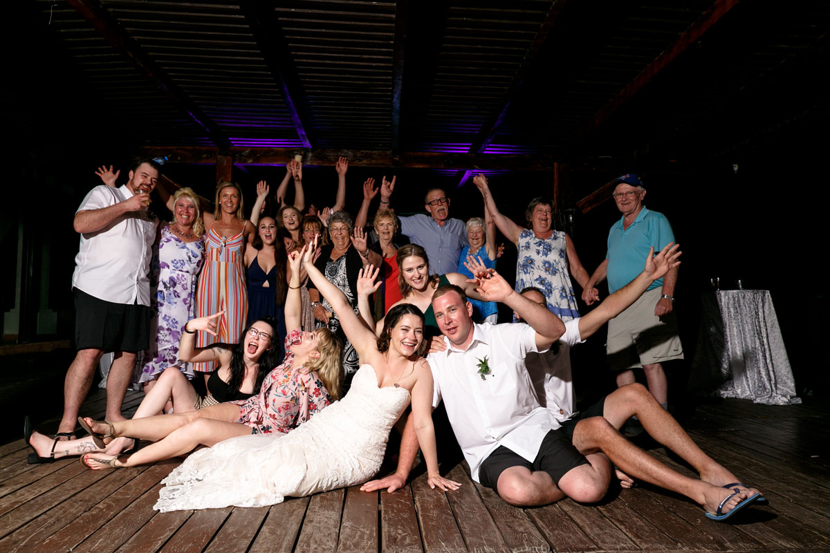 NewlywedsCheerWithWeddingGuestsRaisingArms