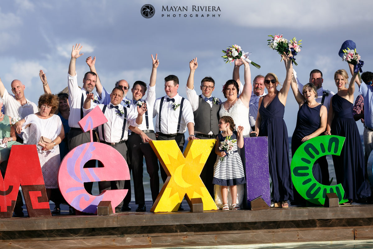 CheeringWeddingPartyAndGuestsBehindMexicoSign