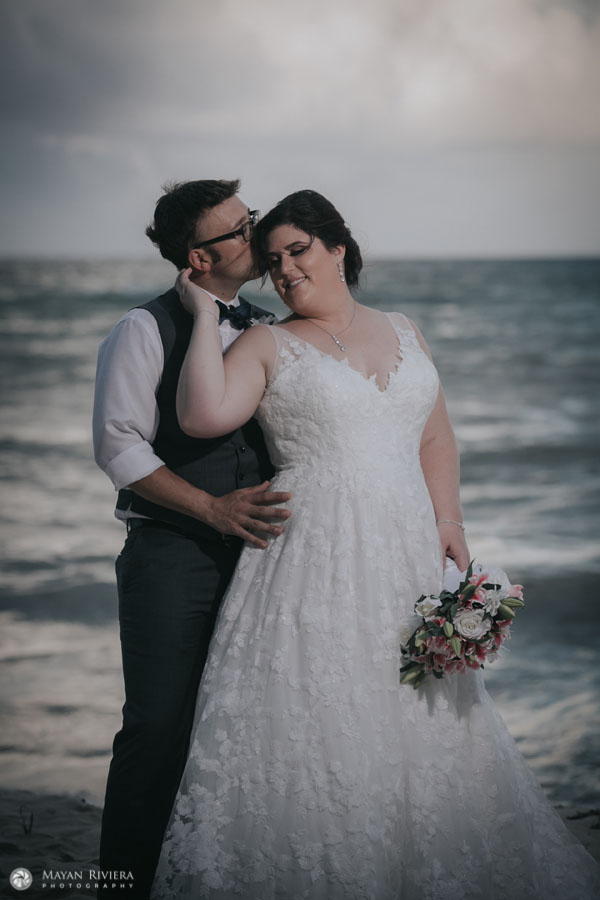 NewlywedsEmbraceOnBeach