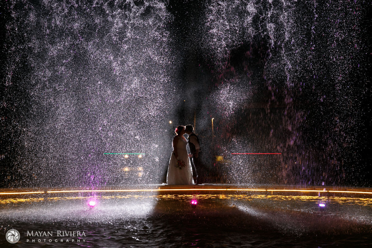 NewlywedsKissBehindPoolWithWaterFall