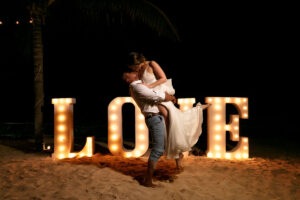 NewlywedsEmbraceByLoveSign