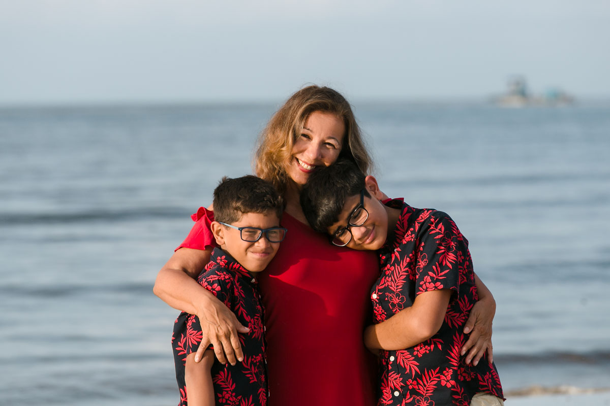 SmilingAuntieHugsNephewsOnBeach