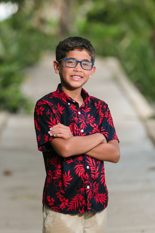 SmilingSonPosesWithArmsFoldedOnJunglePathway