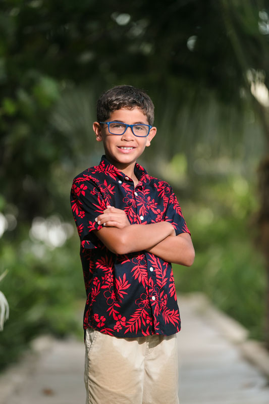 SmilingSonPosesWithArmsFoldedOnJunglePathway