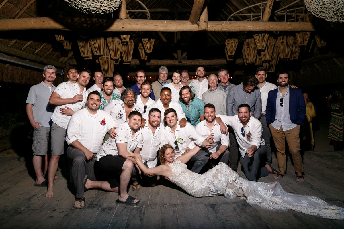 BrideReclinesInFrontOfGuysInGroup