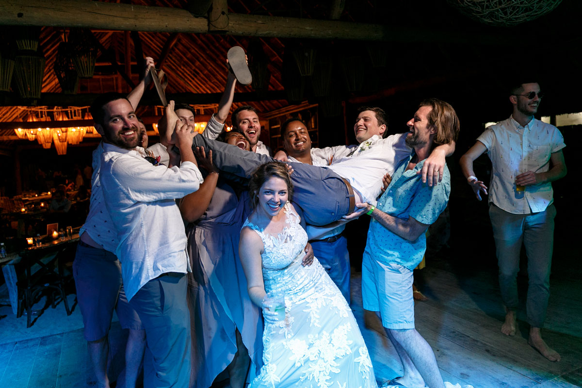 BrideClownsWithGuysHoldingLaughingGroomInTheirArms