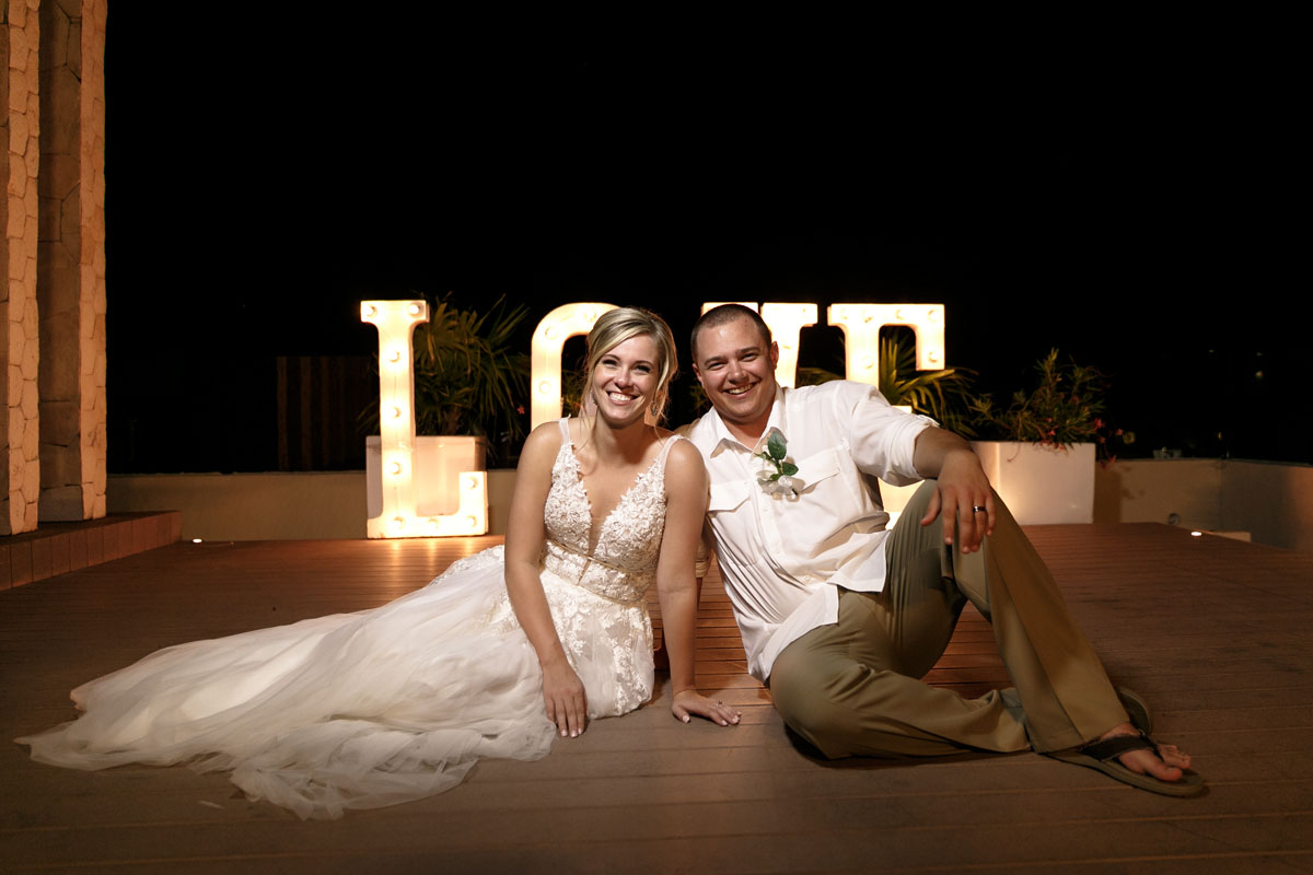 BrideAndGroomInFrontOfLoveSign