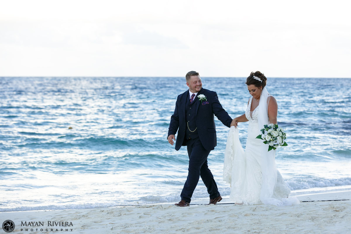 NewlywedsHoldHandsOnBeachwalk