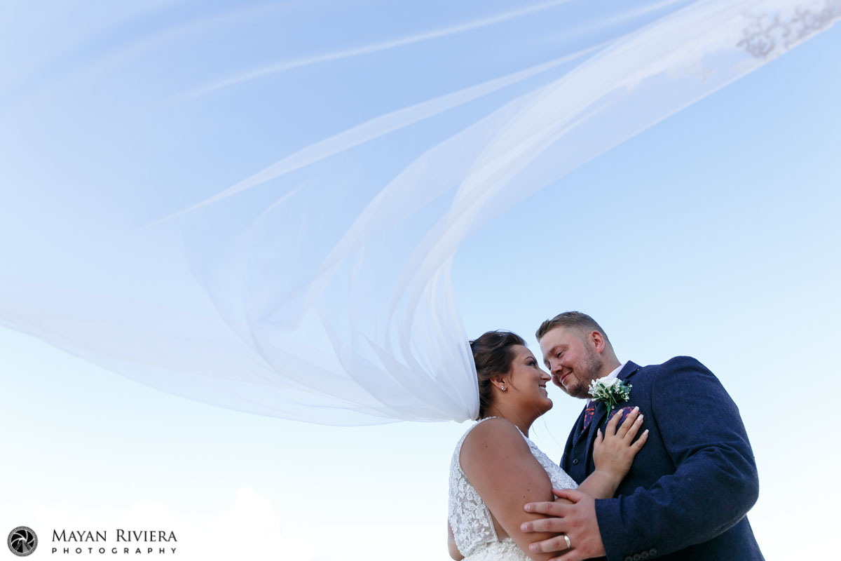 NewlywedsEmbraceUnderFloatingVeil