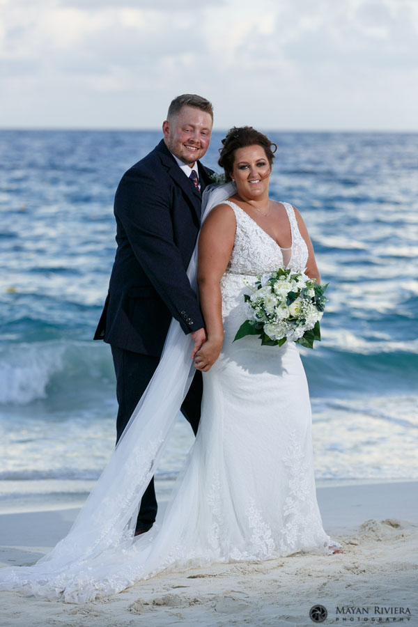 NewlywedsEmbraceOnBeach