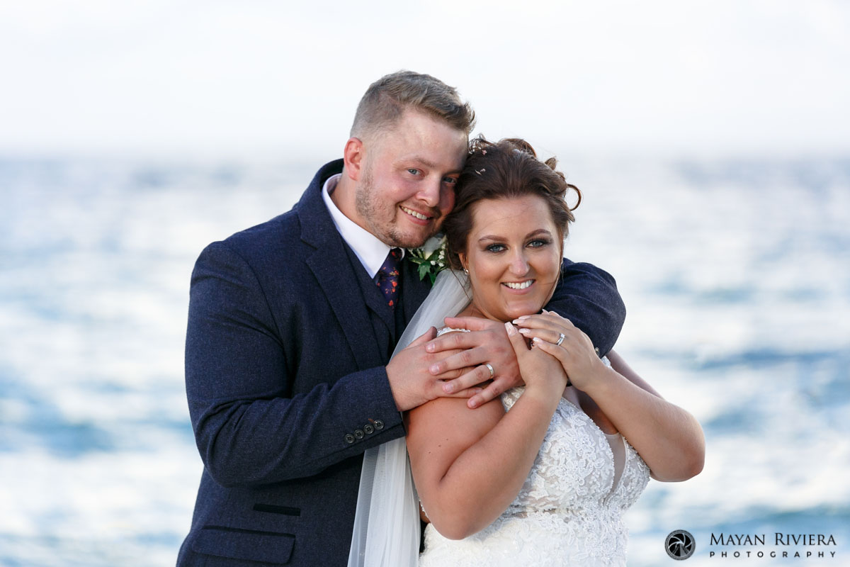 SmilingNewlywedsEmbraceOnBeach